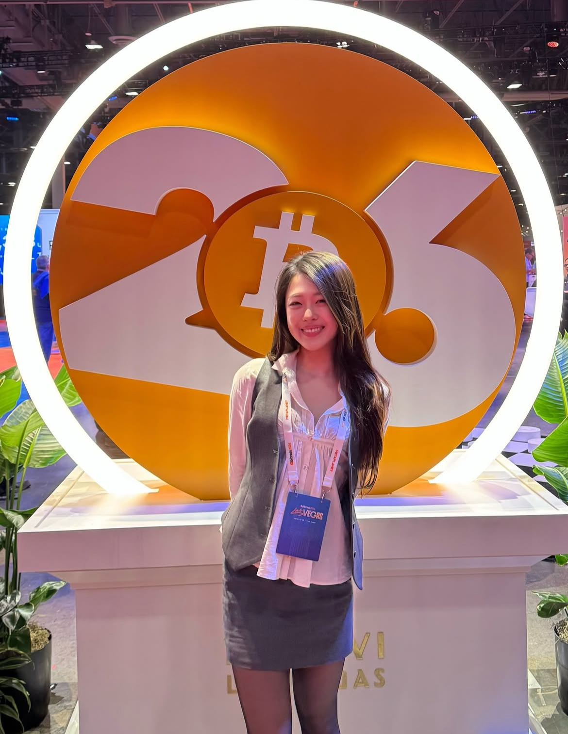 Attendee in front of an illuminated Bitcoin 2026 ring installation